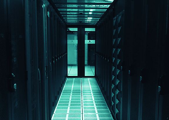 A data-center corridor of server racks, where news-sentiment pipelines run around the clock.
